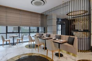 伊斯坦布尔Gleam Bomonti Hotel的餐厅设有桌椅和窗户。
