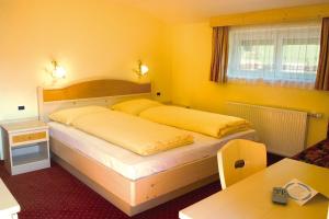 安泰塞尔瓦·迪·梅佐Hotel Bruggerwirt的黄色客房中一间带两张床的卧室