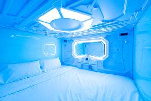 Lapu Lapu CityCapsule hotel Cebu的蓝色的房间,配有床和电视