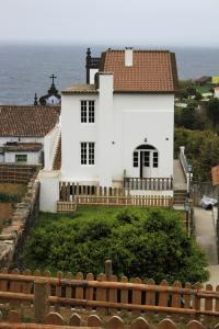 卡佩拉什Casa do Vale do Sossego的一座白色的房子,背景是大海