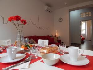 罗马罗马红色公寓的一张桌子,上面有红色的桌布,上面有盘子和杯子