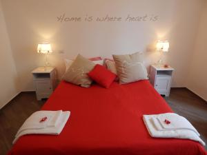 罗马罗马红色公寓的一间卧室配有红色的床和毛巾