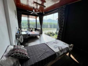 峰牙Nguyen Shack Retreat Resort的一间带一张床铺的卧室,位于带大窗户的房间内