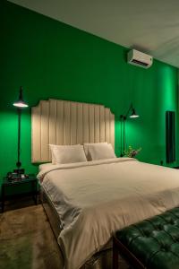 胡志明市HOTEL le JARDIN SECRET saigon的绿色卧室设有一张大床和绿色的墙壁