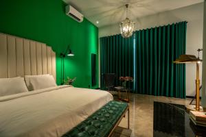 胡志明市HOTEL le JARDIN SECRET saigon的一间卧室设有一张大床和绿色的墙壁