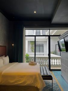 胡志明市HOTEL le JARDIN SECRET saigon的一间卧室设有一张大床和一个大窗户