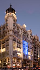 马德里大西洋酒店的一座白色的大建筑,上面有蓝色的标志