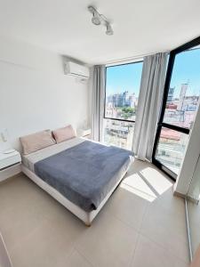 布宜诺斯艾利斯Studio impecable! En el centro de BA con solarium y parrilla的一间卧室设有一张床和一个大窗户