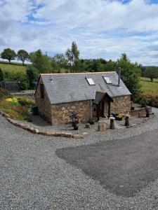 班科里Boghead Cottage: Holiday Cottage in Royal Deeside的路边的一座小石头建筑,窗户