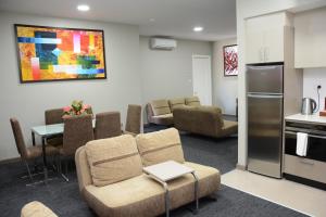 南迪拉笋纳迪机场公寓酒店的带沙发和椅子的客厅以及厨房。
