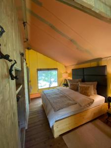 马洪贝GIFFORD private Island GLAMPING boat ride included的卧室配有一张大床,位于拥有黄色墙壁的房间