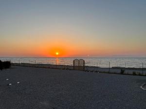 SoroniLambou Beach Sunset的海上的日落,围栏