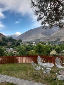 吉塔尔Chitral Green Guest House的一组以山为背景的桌椅