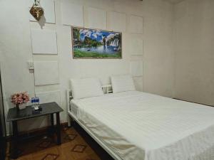 洞海Homestay 117 Bà Triệu - Đồng Hới的一间卧室配有一张床、一张桌子和一张图片