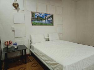 洞海Homestay 117 Bà Triệu - Đồng Hới的卧室配有白色的床和桌子