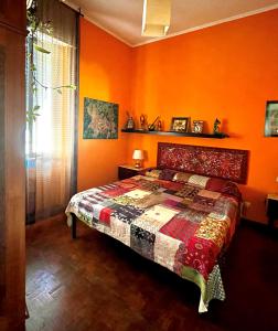 罗马4321 B&B Stazione Trastevere的一间卧室拥有橙色的墙壁,里面设有一张床