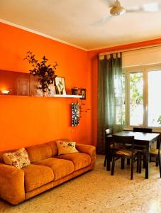 罗马4321 B&B Stazione Trastevere的橙色的客厅配有沙发和桌子