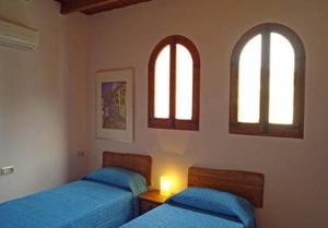 菲内斯特拉特Casa Figueretes的卧室设有两张床,带两个窗户