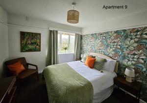 斯凯格内斯Beach Court Holiday Apartments的一间卧室配有一张带花卉壁纸的床