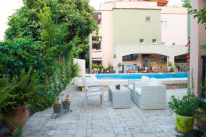 萨索斯Dimitriadis fresh Edem的一个带白色家具的庭院,毗邻游泳池