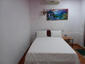 洞海Homestay 117 Bà Triệu - Đồng Hới的一间小卧室,配有白色的床和一张桌子