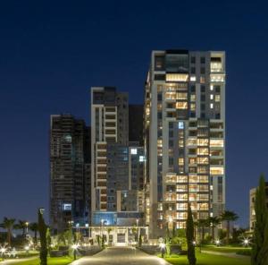 Sheikh ZayedAeon towers El sheikh zayed的一座大建筑,晚上有灯光在城市里