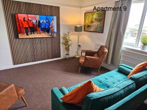 斯凯格内斯Beach Court Holiday Apartments的客厅配有蓝色的沙发和椅子