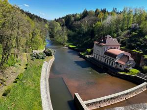 KocléřovTinyhouse u Nosála的享有河流的空中景色,旁边是一座建筑