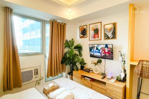 圣费尔南多Spacious Boho-Inspired Studio with Pool View balcony, Netflix, Boardgames & Karaoke的一间卧室设有一张床和一个大窗户