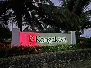 努库阿洛法The Kongakava Hotel的背景棕榈树的孔加泽标志