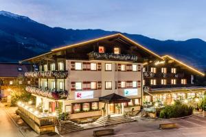 乌登斯Hotel Standlhof Zillertal的夜间在山区的酒店