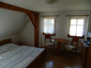 什平德莱鲁夫姆林Privát Fedoriška的一间卧室配有一张床、一张书桌和两个窗户。