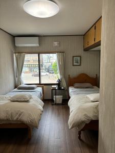 小樽Guest House 来夢的一间卧室设有两张床和大窗户