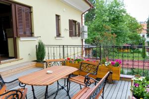 布拉索夫阿里纳公寓酒店的阳台的天井配有木桌和长凳