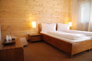 阿列谢尼伊亚拉酒店的一间卧室设有一张床和木墙