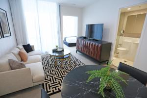 布里斯班亚历克斯佩里酒店及公寓的带沙发、桌子和电视的客厅