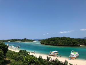 IbarumaPine Shima Resort Coral Fish - Vacation STAY 37446v的三艘船停靠在水面上的海滩上