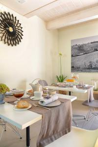 西尼加利亚Resort Il Gallo Senone的一间带桌椅的用餐室和一幅画