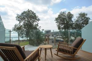 内坦亚海滩住宅酒店的阳台配有桌椅,享有建筑的景致。