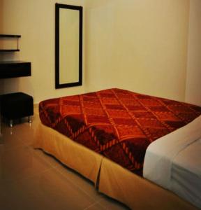 乔治市奥德经济型酒店的一间卧室配有一张红色的床和镜子