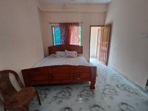 mayapurRadha Gopikanta Guest House - a family Homestay near Iskcon Mayapur的卧室配有床、椅子和窗户。