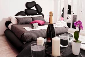 罗马Two Chic Guesthouse的一间设有一张床和一瓶葡萄酒的客房