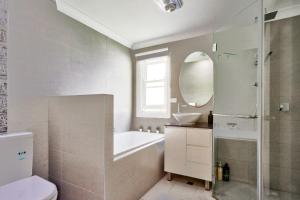 悉尼3 Bedroom House Ideal for Family - Ultimo的带浴缸、水槽和镜子的浴室