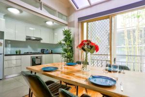 悉尼3 Bedroom House Ideal for Family - Ultimo的餐桌、椅子和花瓶
