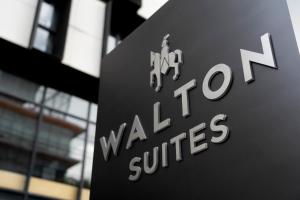 曼谷Walton Suites Sukhumvit的建筑物前面的标志,上面有言语要行来治愈