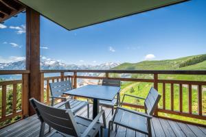 拉普德兹Residence Hameau de Clotaire Alpe d'Huez - by EMERALD STAY的山景甲板上的桌椅