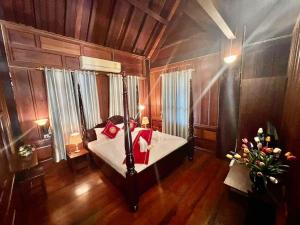 琅勃拉邦Luang Prabang Charming Boutique Hotel的一间卧室配有一张带红色枕头的床