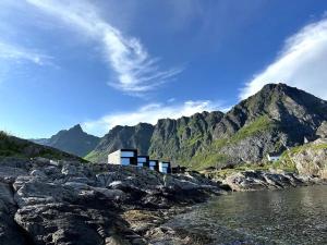 莫斯克内斯High end sea cabins at Å in Lofoten的山边的建筑物,靠近水体