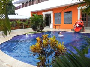 巴里奥斯港Hotel Puerto Libre的住在房子旁边的游泳池里的人