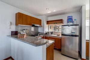 圣玛尔塔Apartamento - Condominio Zazué的厨房配有不锈钢冰箱和木制橱柜